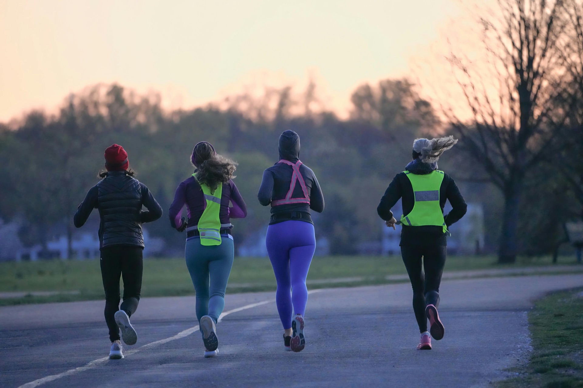 Group of runners on a park road at dusk